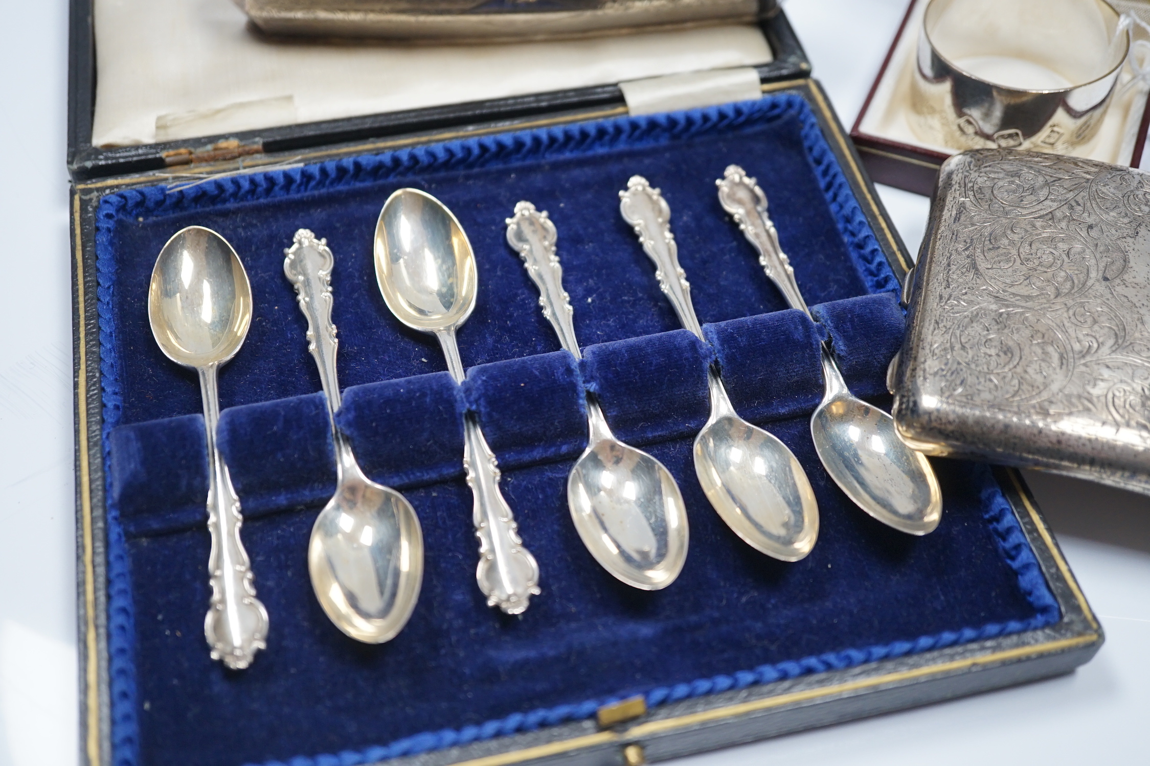 A George V engraved silver mounted nail buffer with cover, Birmingham, 1928, 14.9cm, together with a silver cigarette case, a silver napkin ring and a cased set of six silver teaspoons.